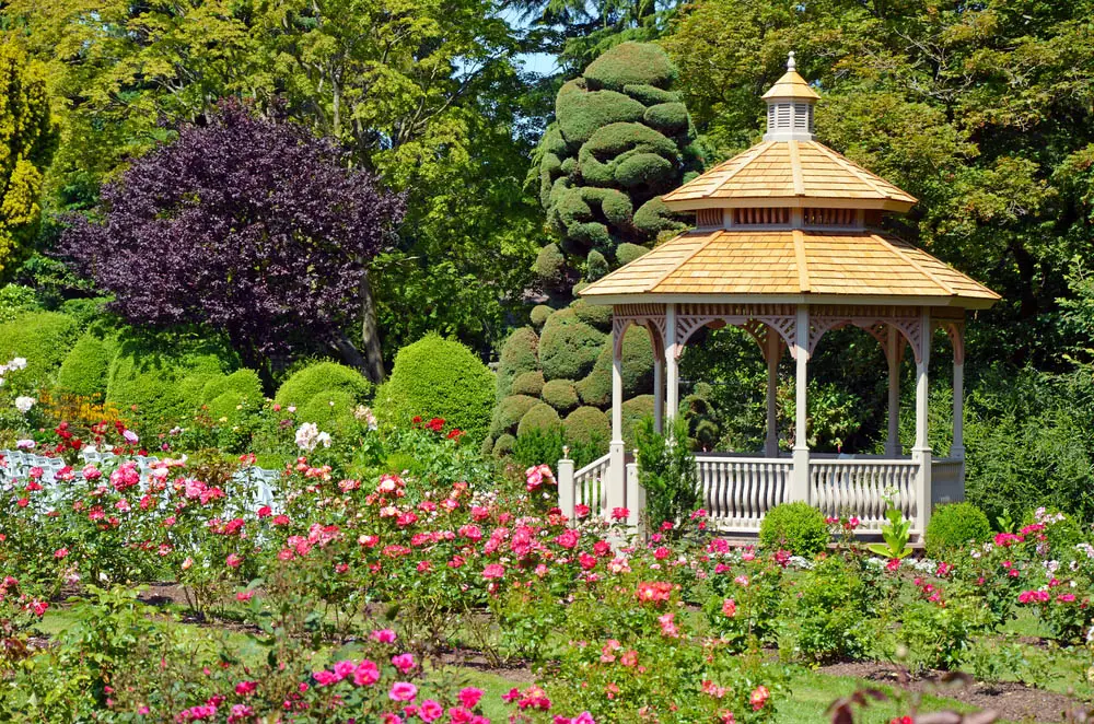 With its railings and support arches done up like an ornate porch fence, this gazebo looks ready to impress. Topped with a light natural wood tile roof in three layers, with a bespoke peak at the top, it's a subtly complex structure that stands out in stark elegance amidst a garden. A gazebo like this might be best designed to match the roof of your home.