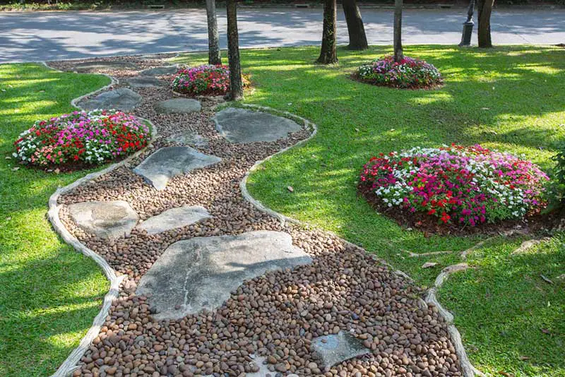 If you love stone garden paths as much as we do, you'll know that they do best when framed with a well manicured lawn or garden. This landscape makes the best of both worlds by dotting the surrounding grass with little islands of color in the form of impatiens.